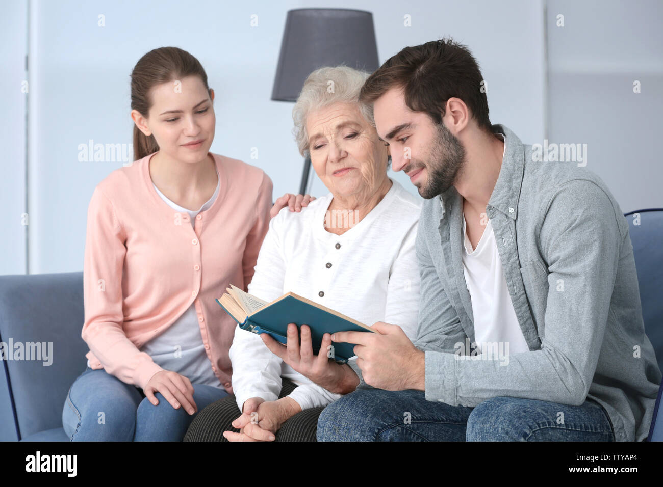 Großmutter mit Enkel lesen Buch auf dem Sofa Stockfoto