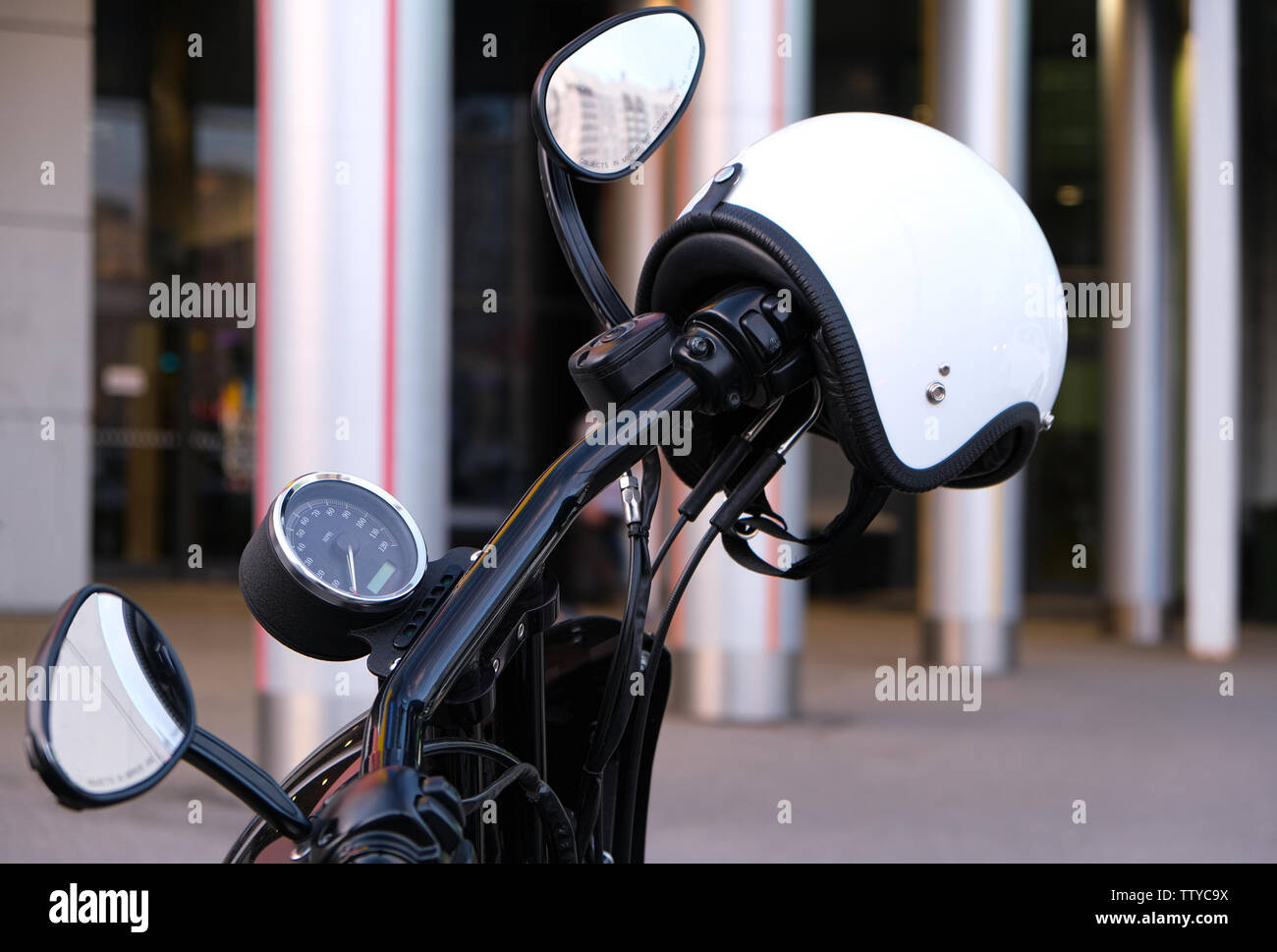 Die Gas und Bremse am Lenker des Motorrades mit Chrom- und weißen Helm ohne Visier. Einen weißen Helm hängen am Griff der m Stockfoto