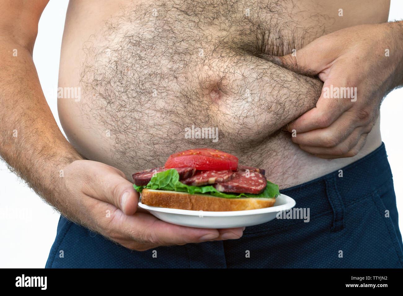 Menschen mit Übergewicht. symbolische Foto für Bier Bauch, erfolglosen Diäten und Ernährung die falschen Nahrungsmittel. Gewicht-verlust-Konzept. Enge T-Shirt. Stockfoto