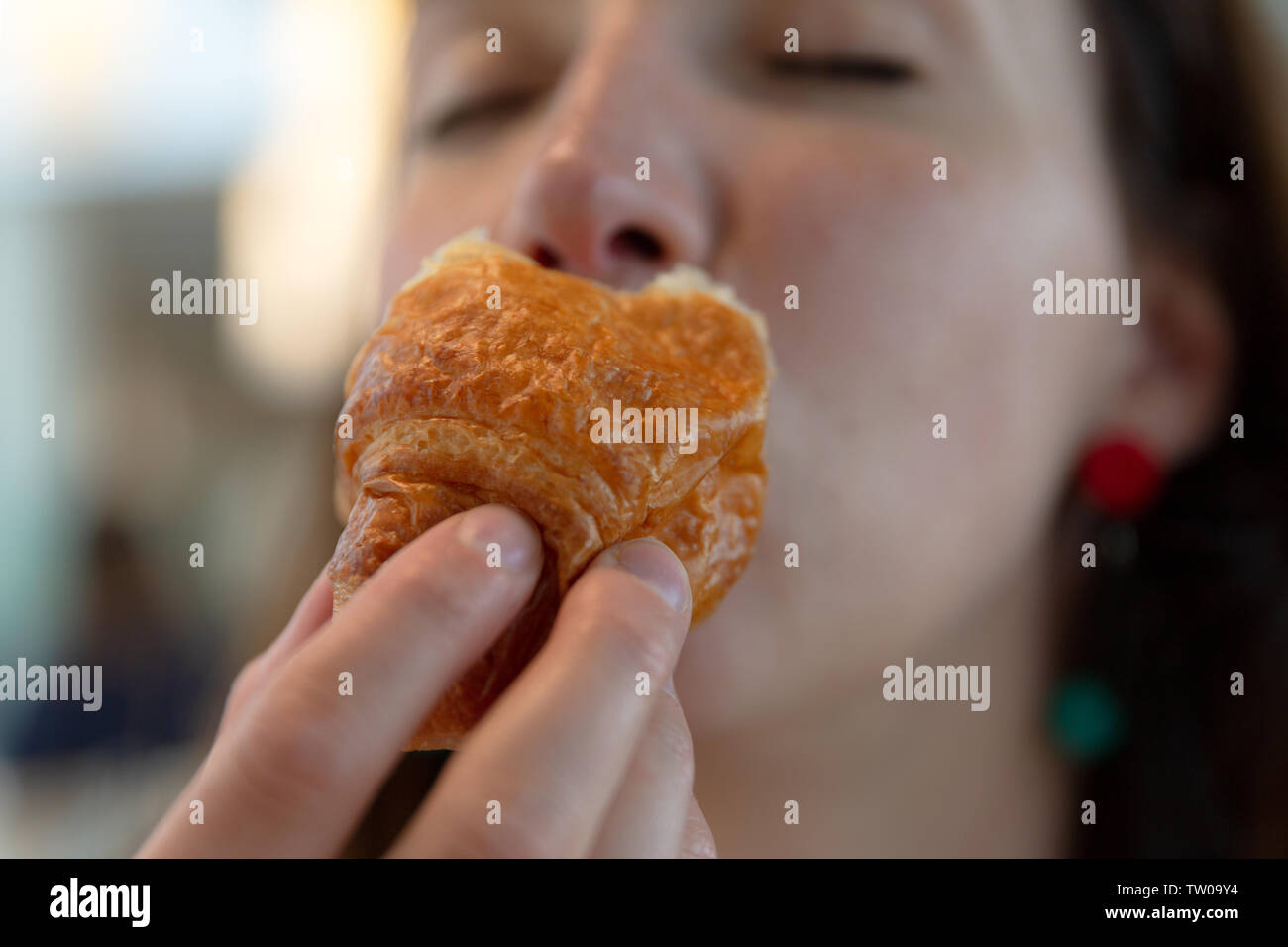 Junge Frau isst Croissant, Genuss, Schuld frei Essen Stockfoto