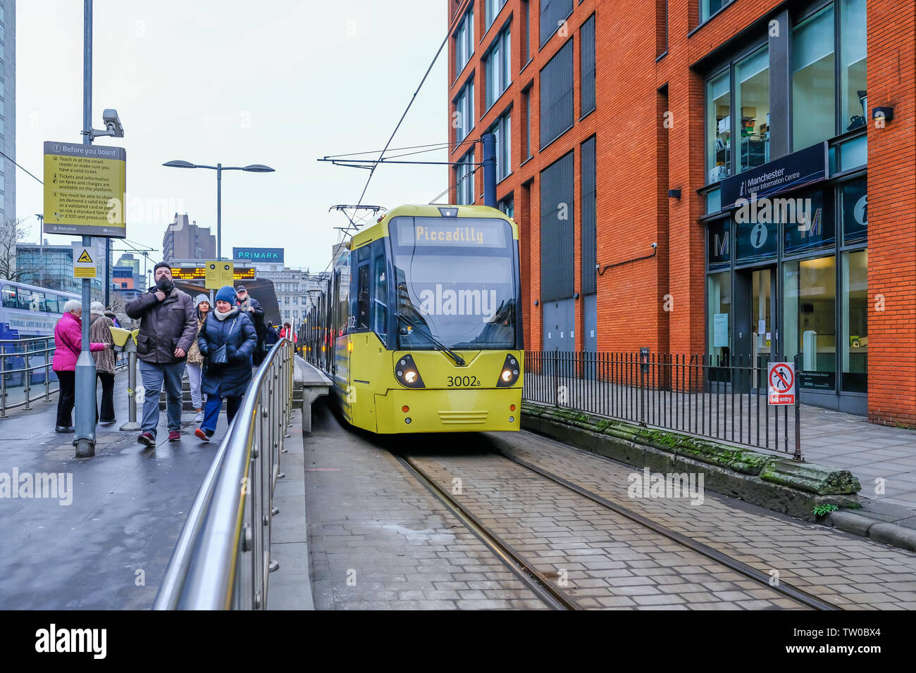 Die Piccadilly, Manchester, UK - Januar 19, 2019: Gelb Straßenbahn an der Haltestelle Picadilly mit Passagieren die Station zu verlassen 1. Stockfoto