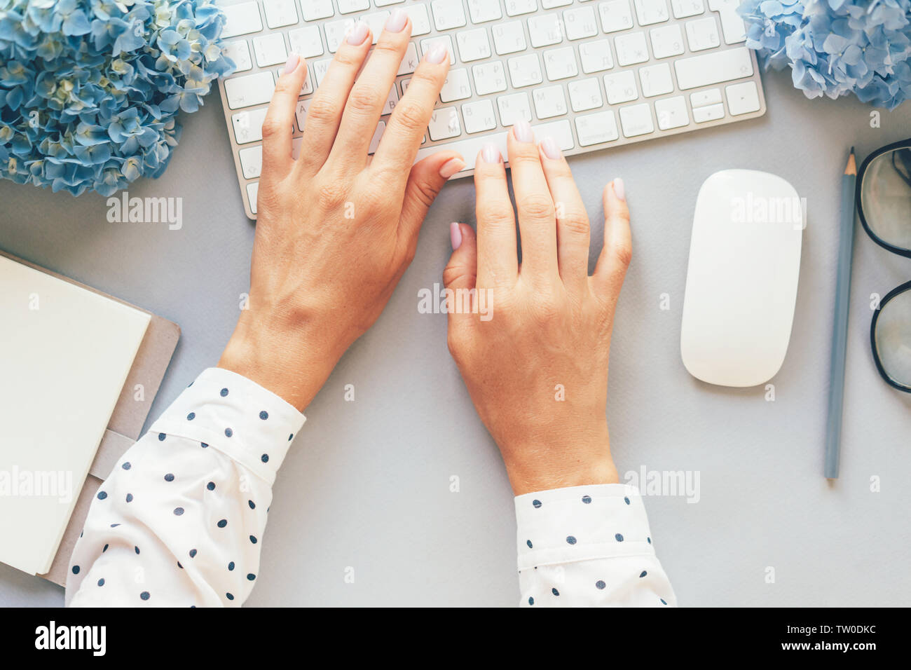 Office Konzept, Blick von oben auf die Hände in einer Polka-dot Shirt die Eingabe über die Tastatur des Computers, modische business lady Blogger hält Ihr blog auf der Website. Stockfoto
