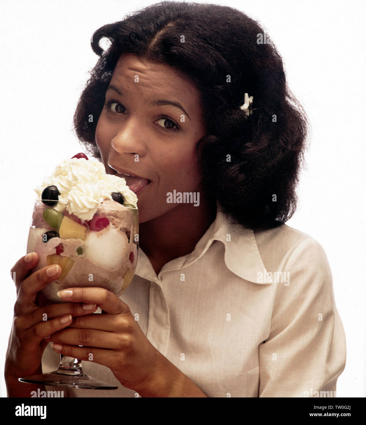 Porträt der deutschen Schlager - Disco- und Popsängerin Ramona Wulf 5/6 für Sie ein einem großen Eisbecher schleckt, Deutschland Ca. 1972. Porträt des deutschen Pop, Disco und Pop Sängerin Ramona Wulf, während Sie leckt ein großer Eisbecher, Deutschland Ca. 1972. Stockfoto