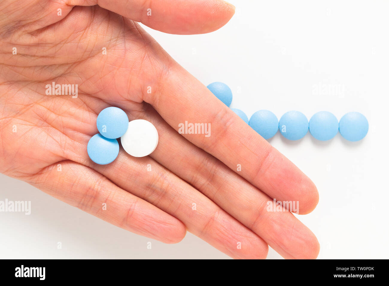 Gesundheit und Medikamente Konzept blaue und weiße Pillen, Drogen oder Tabletten in der Frau hand mit Kopie Raum Stockfoto