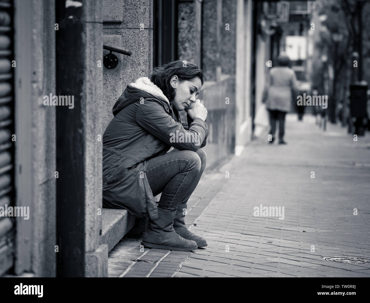 Attraktive Frau, die unter Depressionen leiden Holzeinschlag untröstlich traurig, unglücklich und einsam sitzen in Stadt Urban Street in der psychischen Gesundheit emotionalen Schmerz Abu Stockfoto