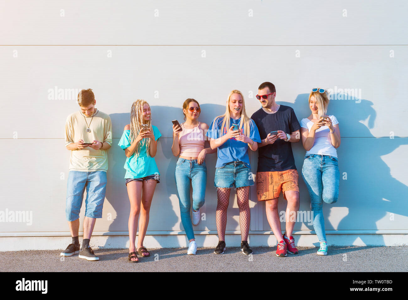 Gruppe von Jugendlichen über ihre Mobiltelefone Stockfoto