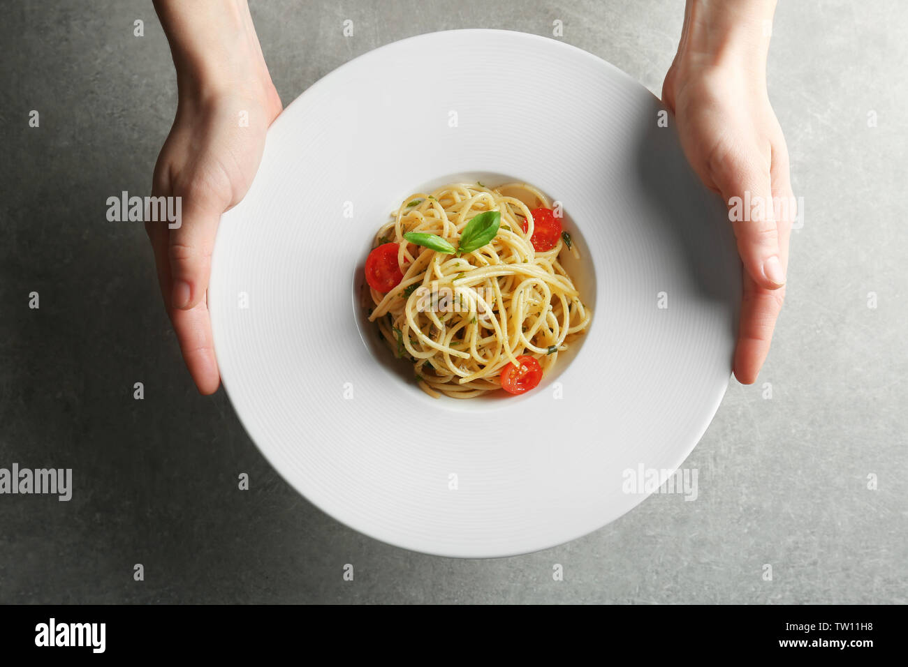 Frau hält Teller mit leckeren Pasta Stockfoto