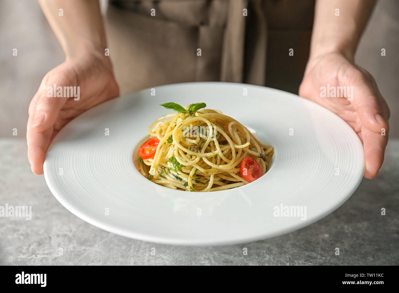 Frau hält Teller mit leckeren Pasta Stockfoto