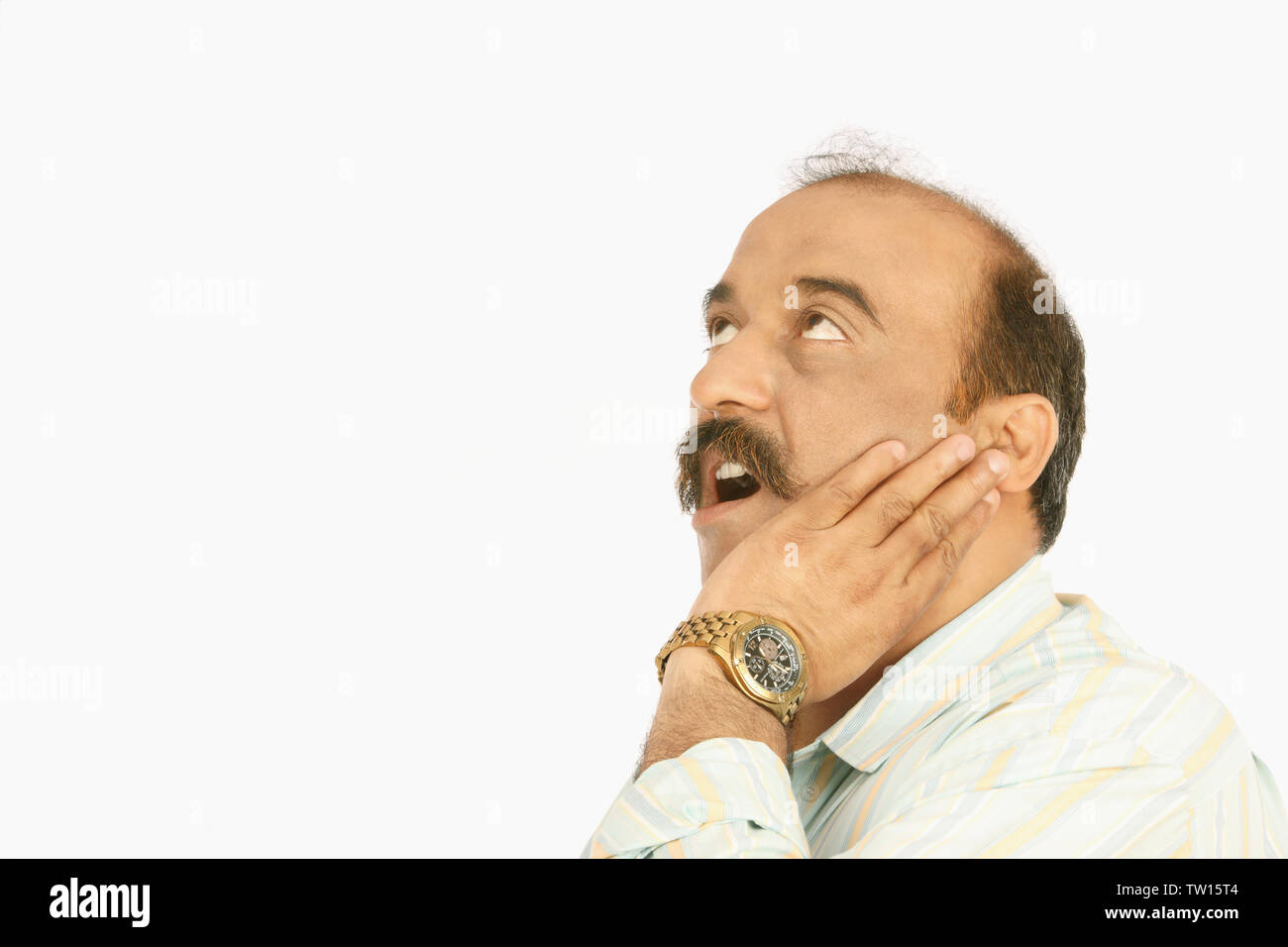 Reifer Mann hält seine Wange Stockfoto