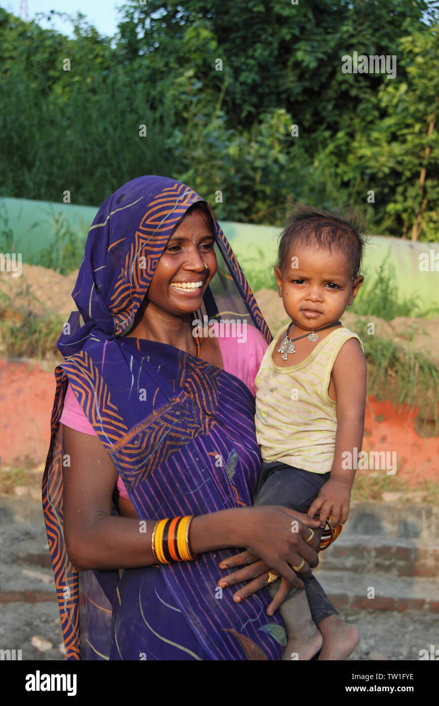 Frau trägt ihren Sohn und lächelt, Indien Stockfoto