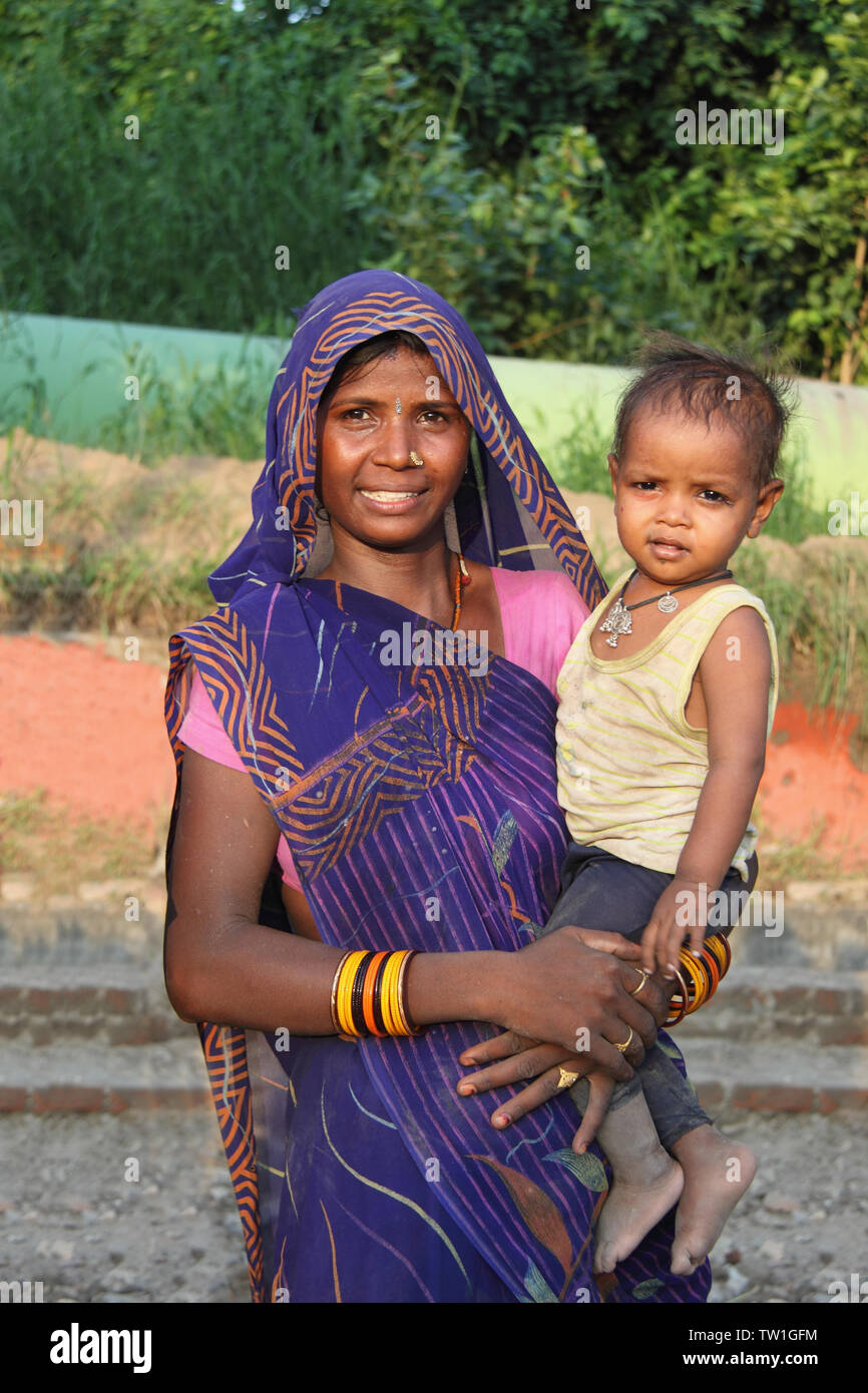 Porträt einer Frau, die ihren Sohn trägt, Indien Stockfoto