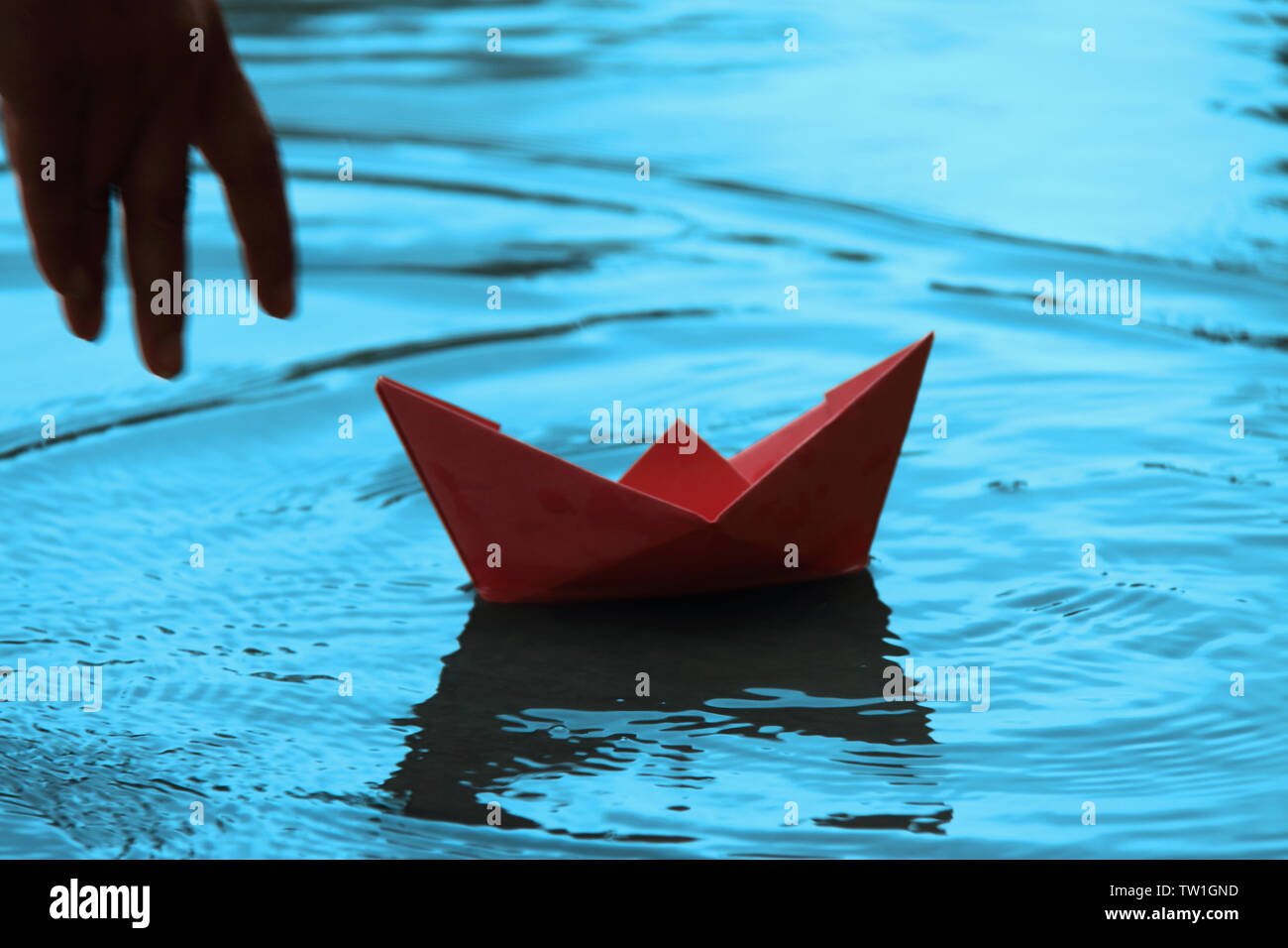 Papierboot auf dem Wasser schwimmt Stockfoto