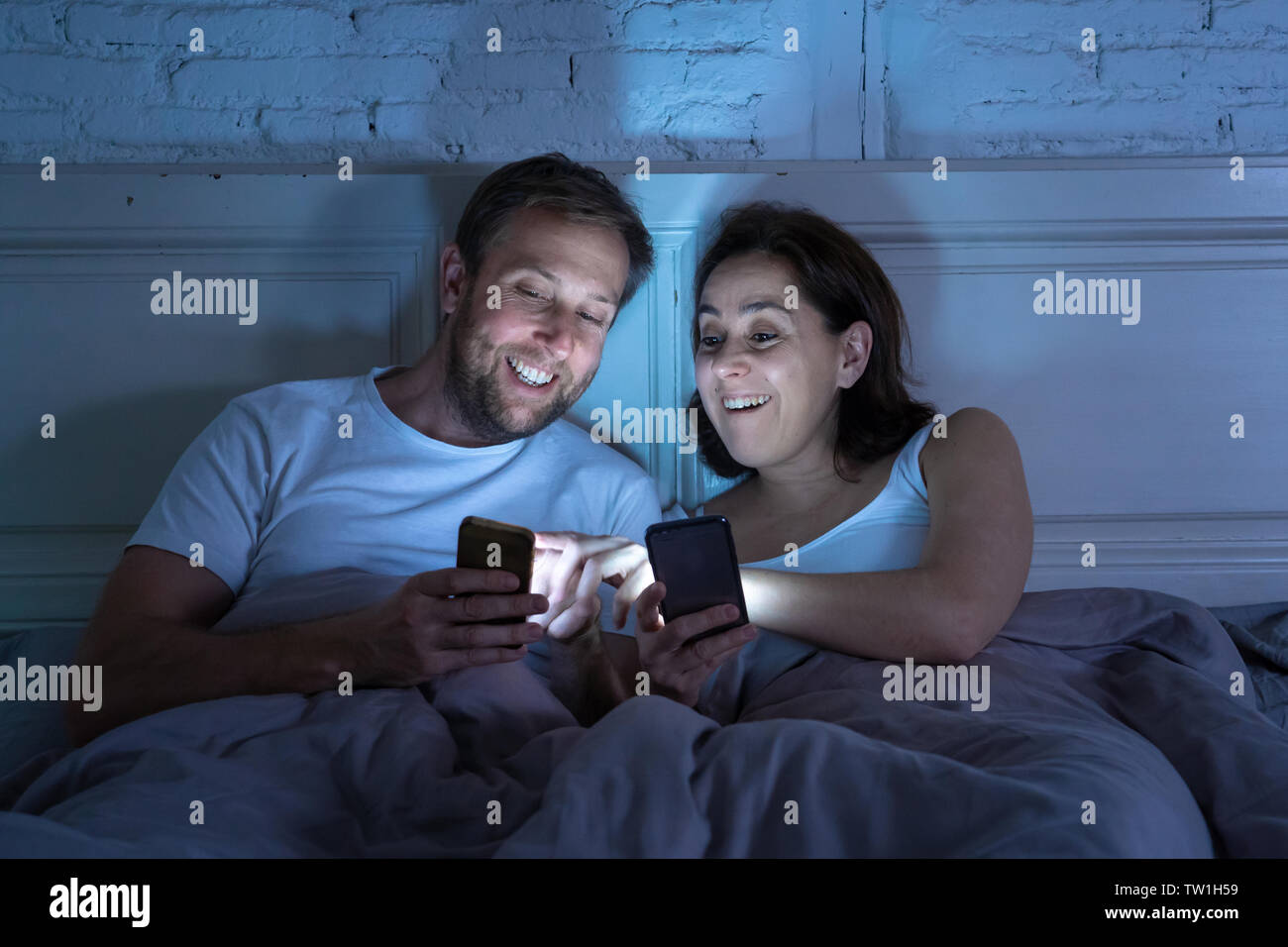Lächelnd attraktive junge Männer und Frau Paar mit Smartphone auf dem Bett zusammen liegen. Gerne Freund und Freundin Kontrolle soziale Netzwerke oder mobil Stockfoto Lächelnd attraktive junge Männer und Frau Paar mit Smartphone auf dem Bett zusammen liegen. Gerne Freund und Freundin Kontrolle soziale Netzwerke oder mobil Stockfoto