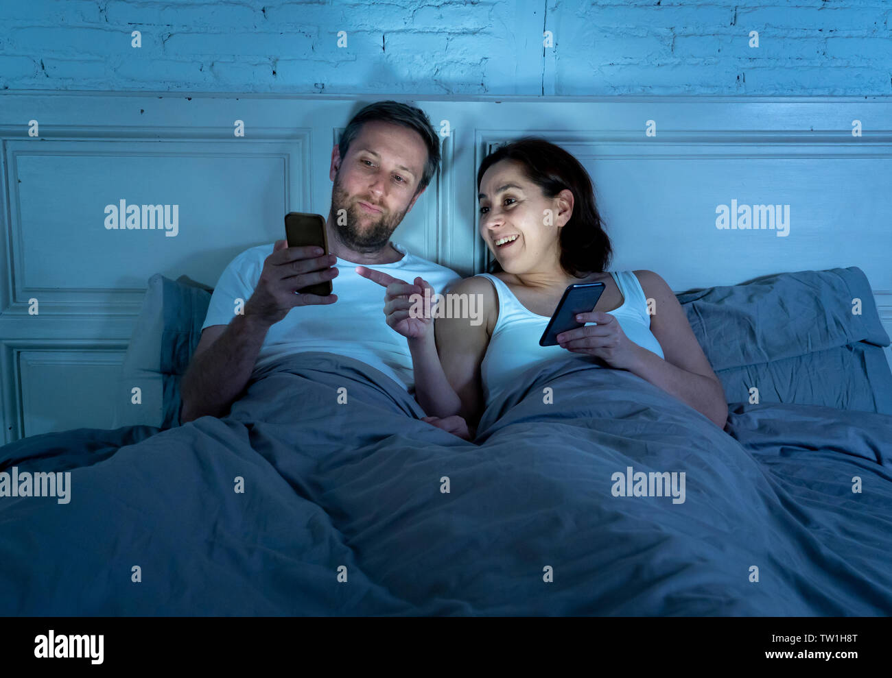 Lächelnd attraktive junge Männer und Frau Paar mit Smartphone auf dem Bett zusammen liegen. Gerne Freund und Freundin Kontrolle soziale Netzwerke oder mobil Stockfoto Lächelnd attraktive junge Männer und Frau Paar mit Smartphone auf dem Bett zusammen liegen. Gerne Freund und Freundin Kontrolle soziale Netzwerke oder mobil Stockfoto