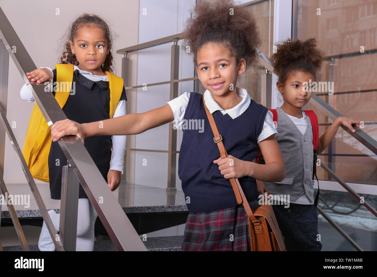 Nette afroamerikanische Mädchen auf der Treppe an der Schule Stockfoto