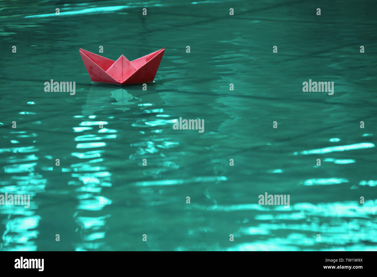 Papierboot auf dem Wasser schwimmt Stockfoto