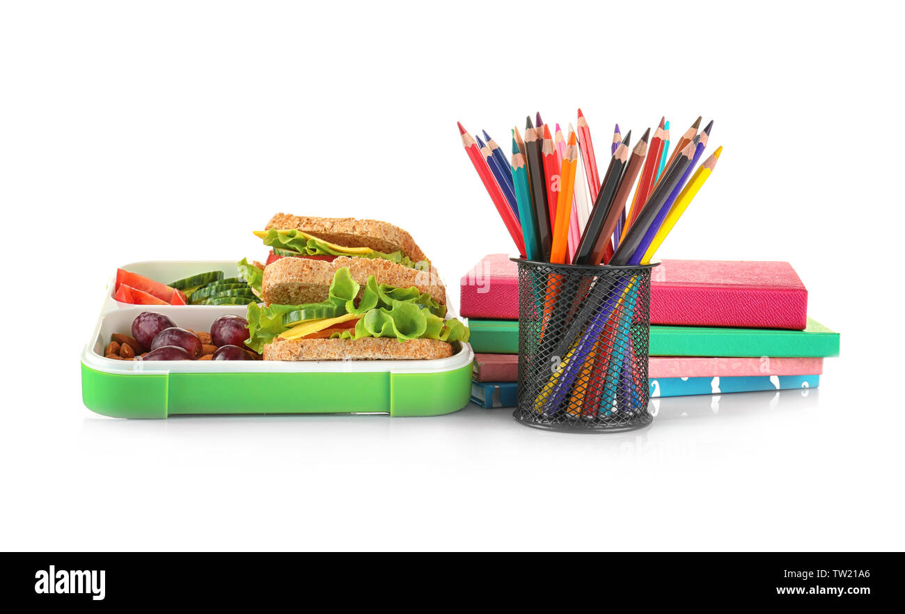 Lunch Box mit Nahrungsmitteln und Schreibwaren auf weißem Hintergrund Stockfoto