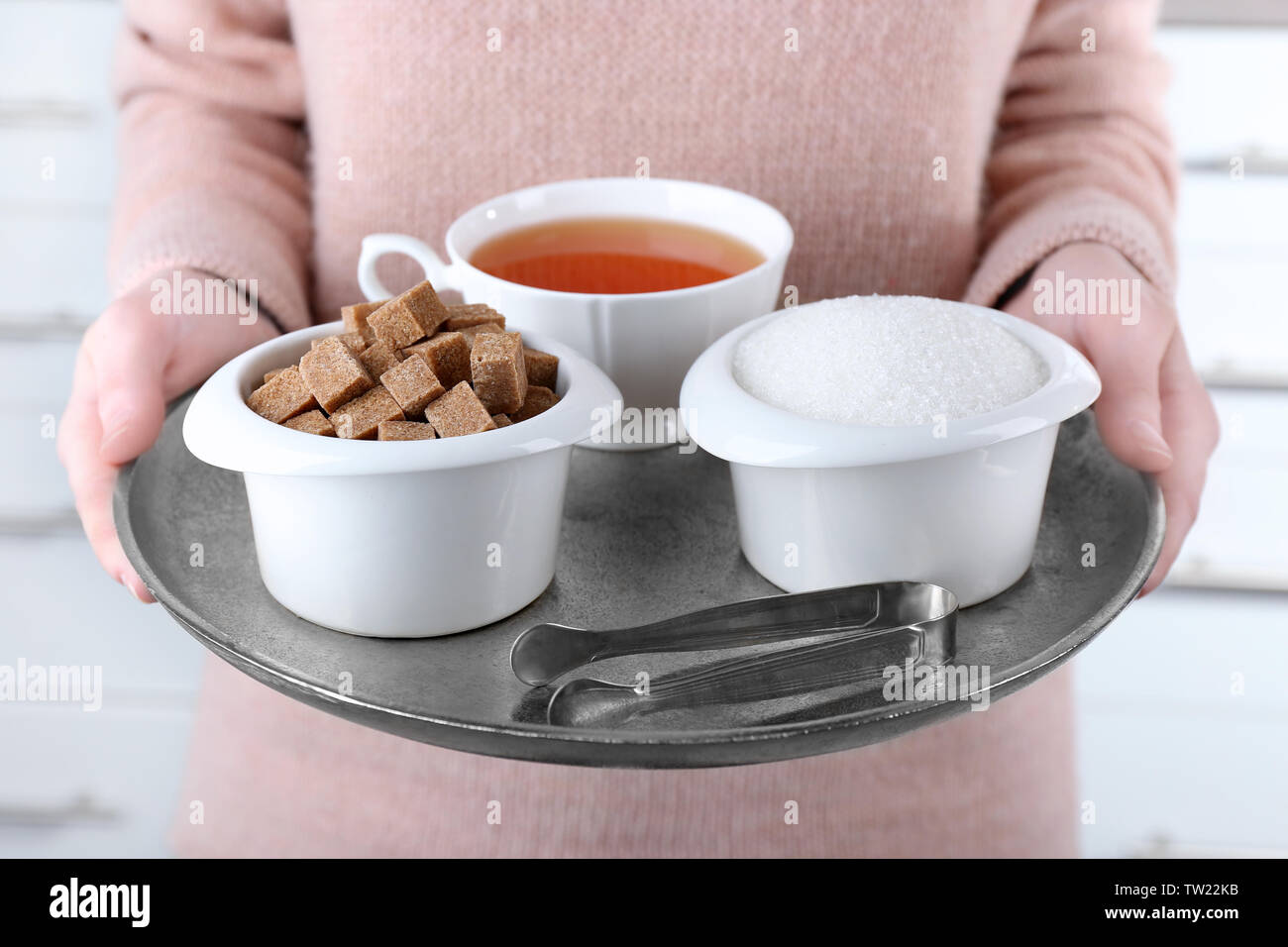 Frau mit Metallmantel mit Zucker Schüsseln und Tasse schwarzen Kaffee Stockfoto