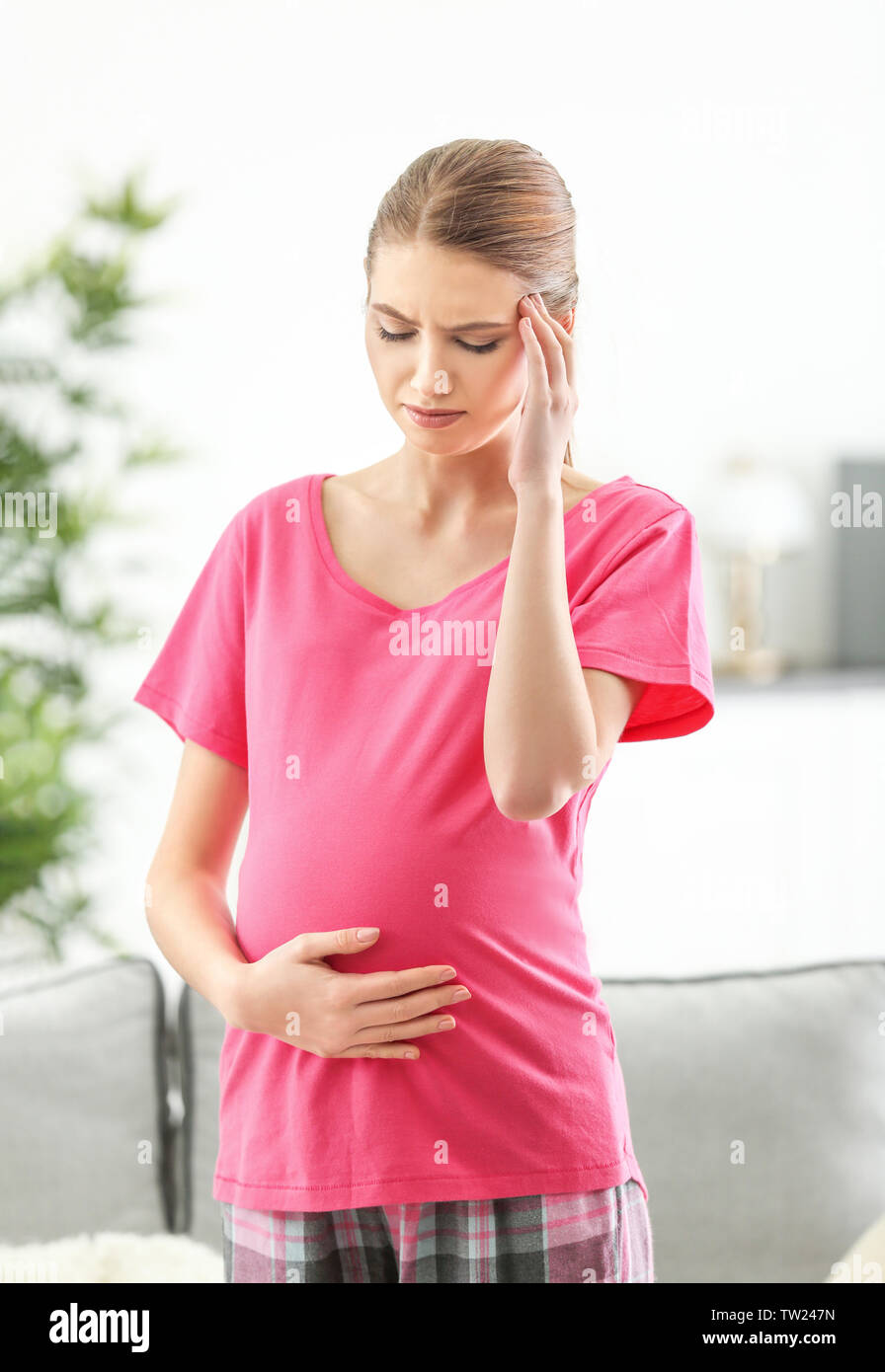 Schwangere Frau leidet unter Kopfschmerzen zu Hause Stockfoto