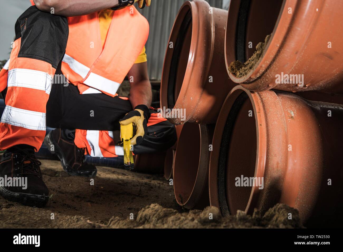 Abwasser Rohrleitungsbau Projekt. Arbeitnehmer Vorbereitung von Kunststoffrohren für die Installation. Industrielle Thema. Stockfoto