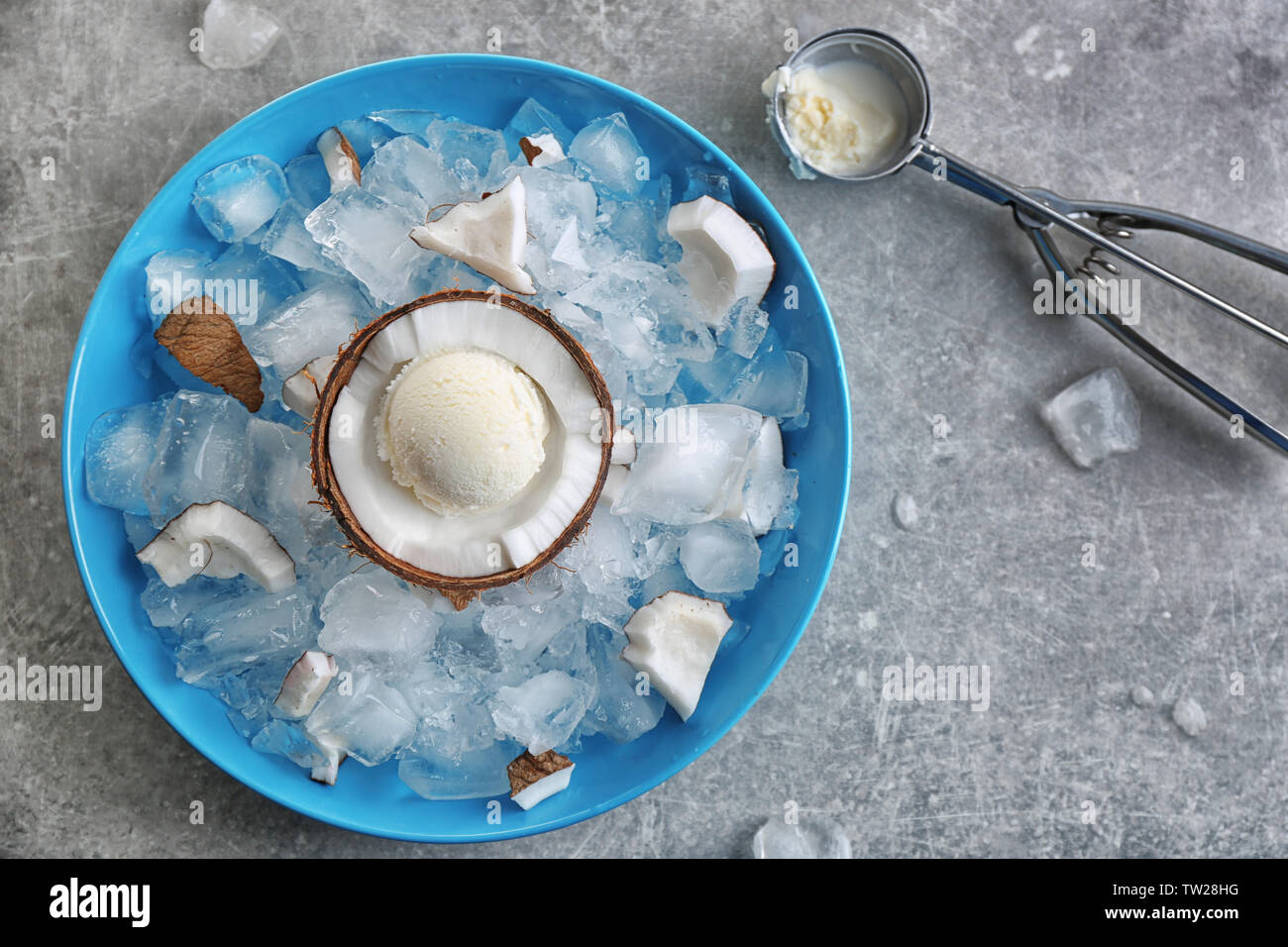 Die Hälfte der Kokosnuss mit frischem Eis Ball Kühlung auf eisigen Würfel in blaue Schale Stockfoto