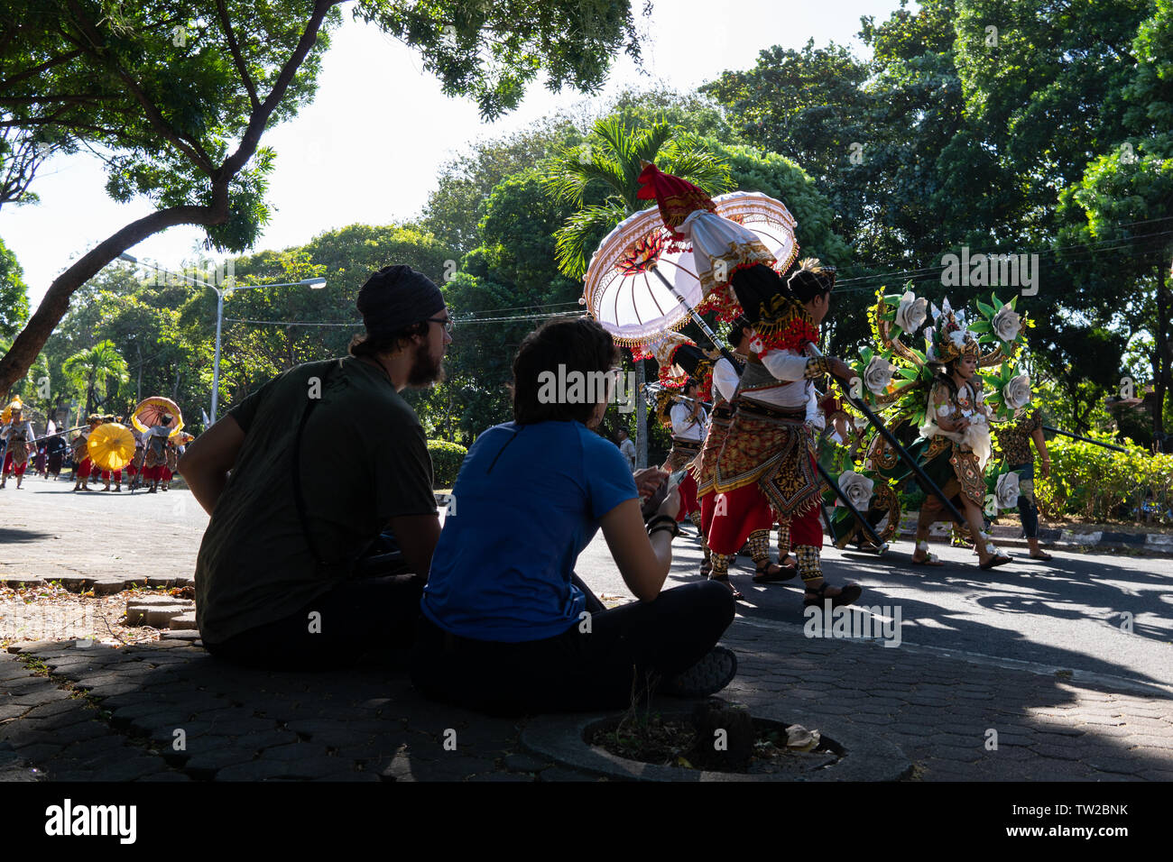 DENPASAR/BALI - 15. JUNI 2019: ein paar Touristen aus Europa beobachten einen traditionellen Tanz Parade bei der Eröffnung der 2019 Bali Kunst Party Stockfoto