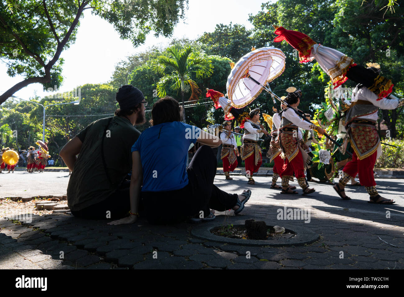 DENPASAR/BALI - 15. JUNI 2019: ein paar Touristen aus Europa beobachten einen traditionellen Tanz Parade bei der Eröffnung der 2019 Bali Kunst Party Stockfoto