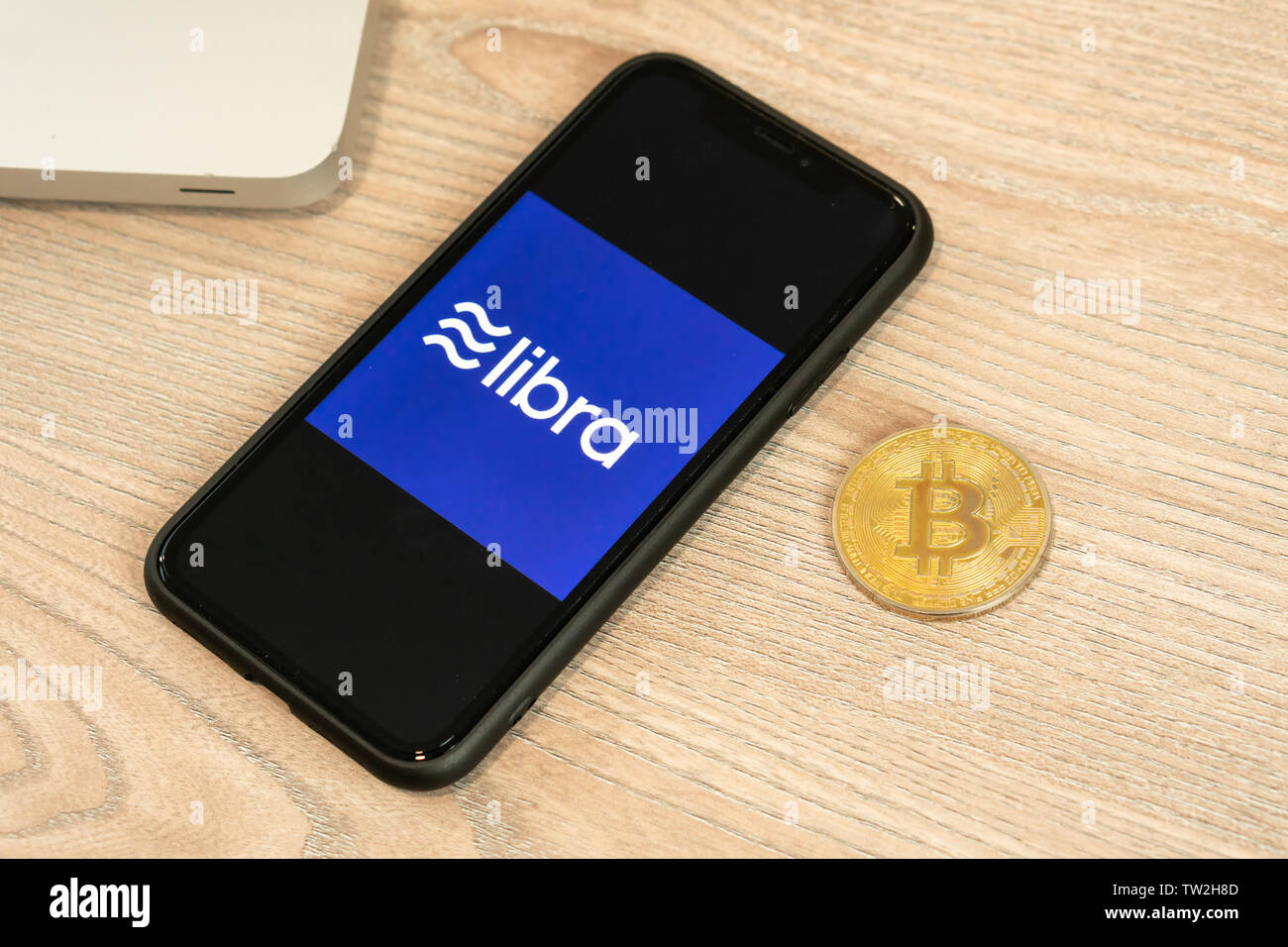 18. Juni 2019, Ljubljana, Slowenien - Smartphone mit Waage Logo auf, neben Bitcoin Münze. Facebook Neue globale cryptocurrency für Transaktionen Stockfoto