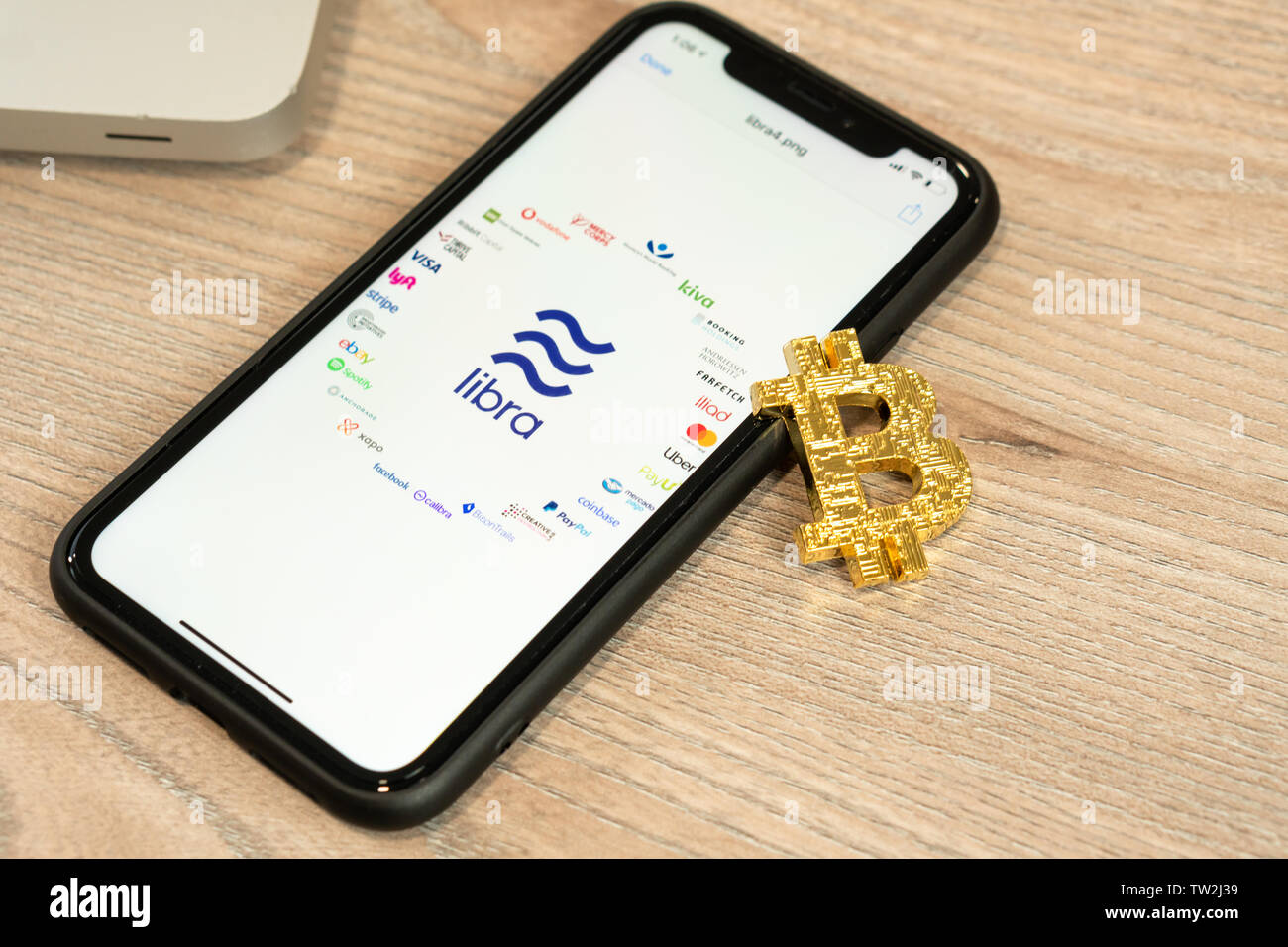 18. Juni 2019, Ljubljana, Slowenien - Smartphone mit Waage Logo und seine Partner, neben Bitcoin Münze. Facebook Neue cryptocurrency Stockfoto