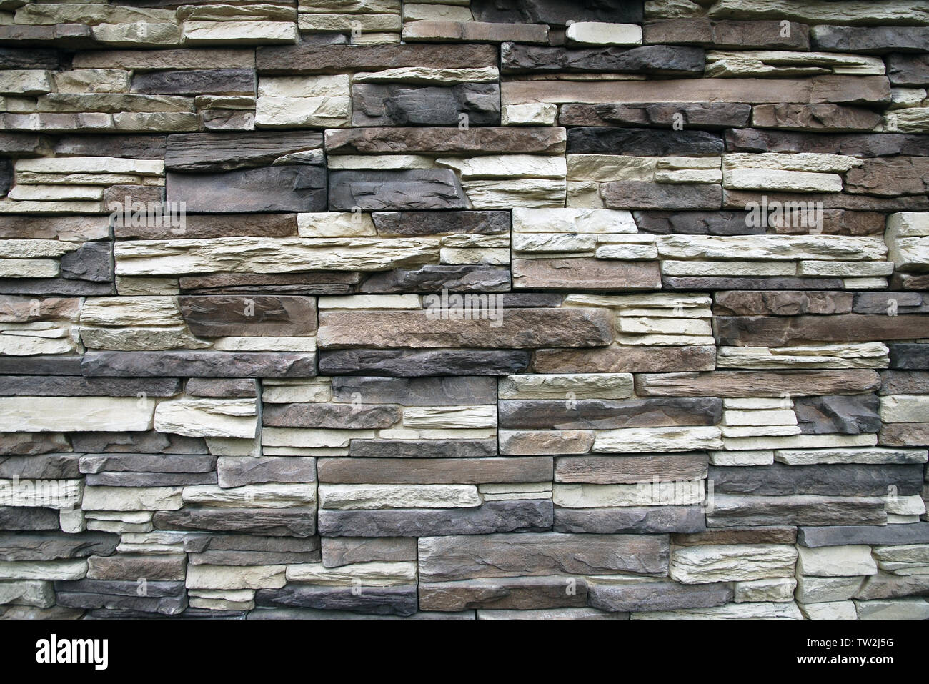 Stein Wand Textur Hintergrund von schmalen, flachen Steinen in braun, grau, beige Farben Stockfoto
