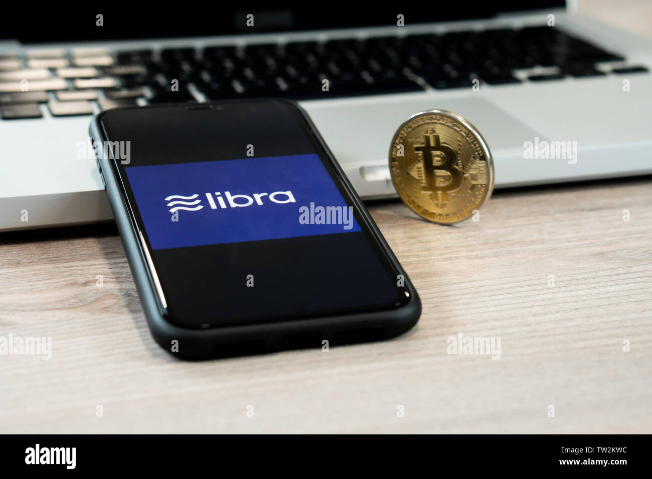 18. Juni 2019, Ljubljana, Slowenien - Smartphone mit Waage Logo auf, neben Bitcoin Münze. Facebook Neue globale cryptocurrency für Transaktionen Stockfoto