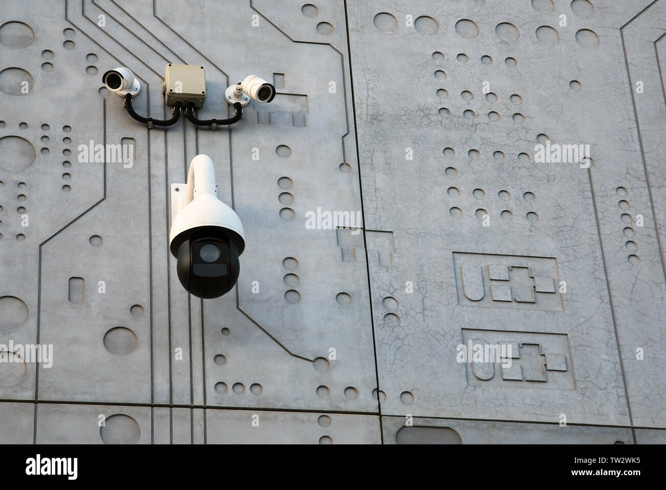 Drei externe Überwachungskameras weiss mit Schwarz auf grauem Beton wand hintergrund stilisierte wie microcircuit Chip Stockfoto