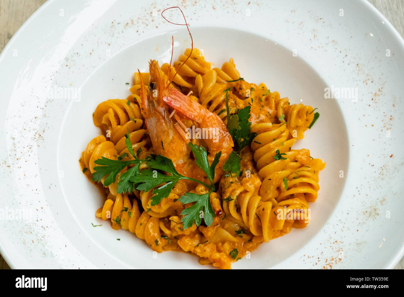 Nahaufnahme der Italienische fusilli Garnelen und Meeresfrüchte Pasta mit Sahne und Tomatensauce in eine weiße Platte isolierte natürliche Beleuchtung von professionellen Italia gekocht Stockfoto