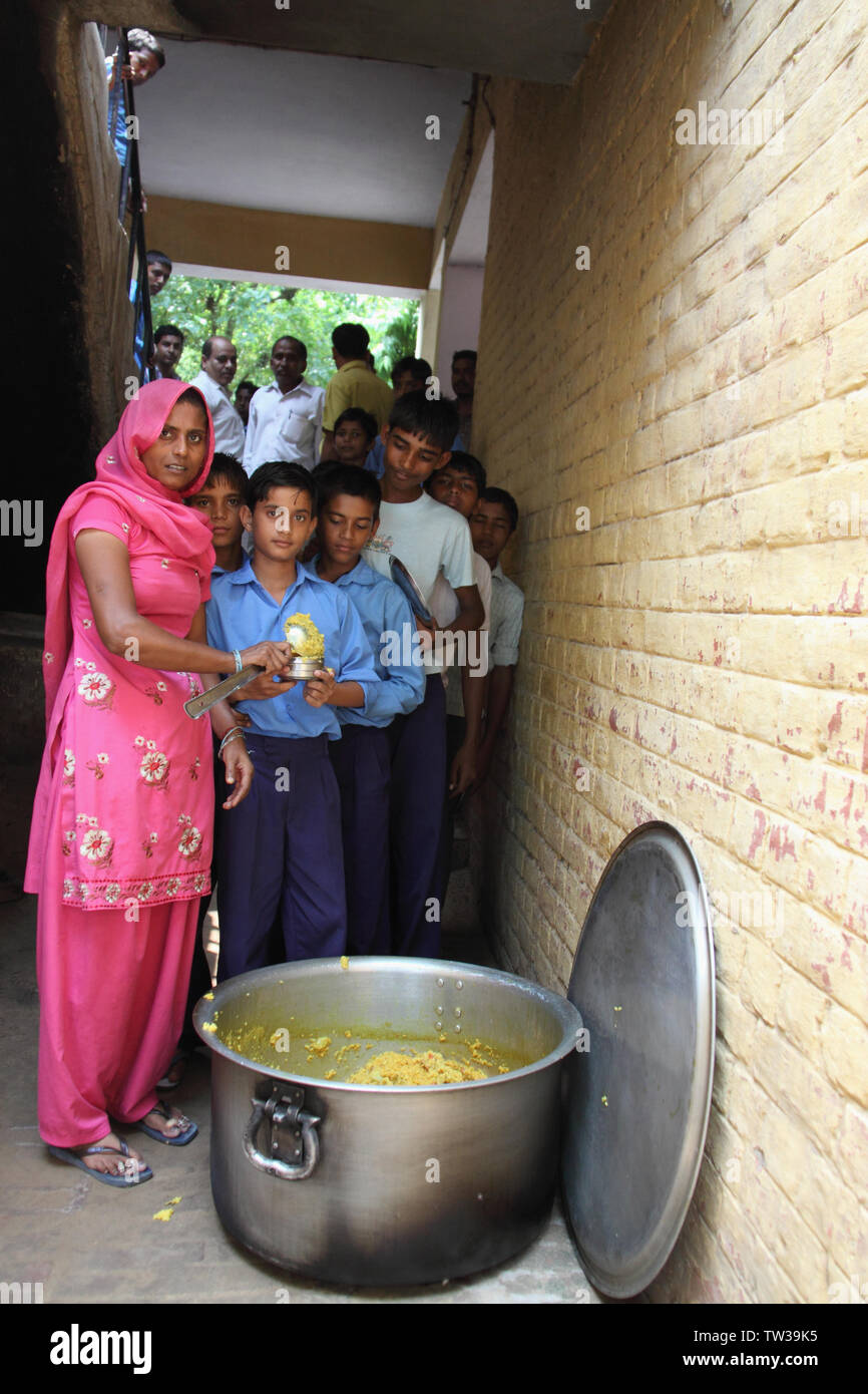 Anganwadi-Arbeiter, der Studenten, Indien, Nahrung gibt Stockfoto