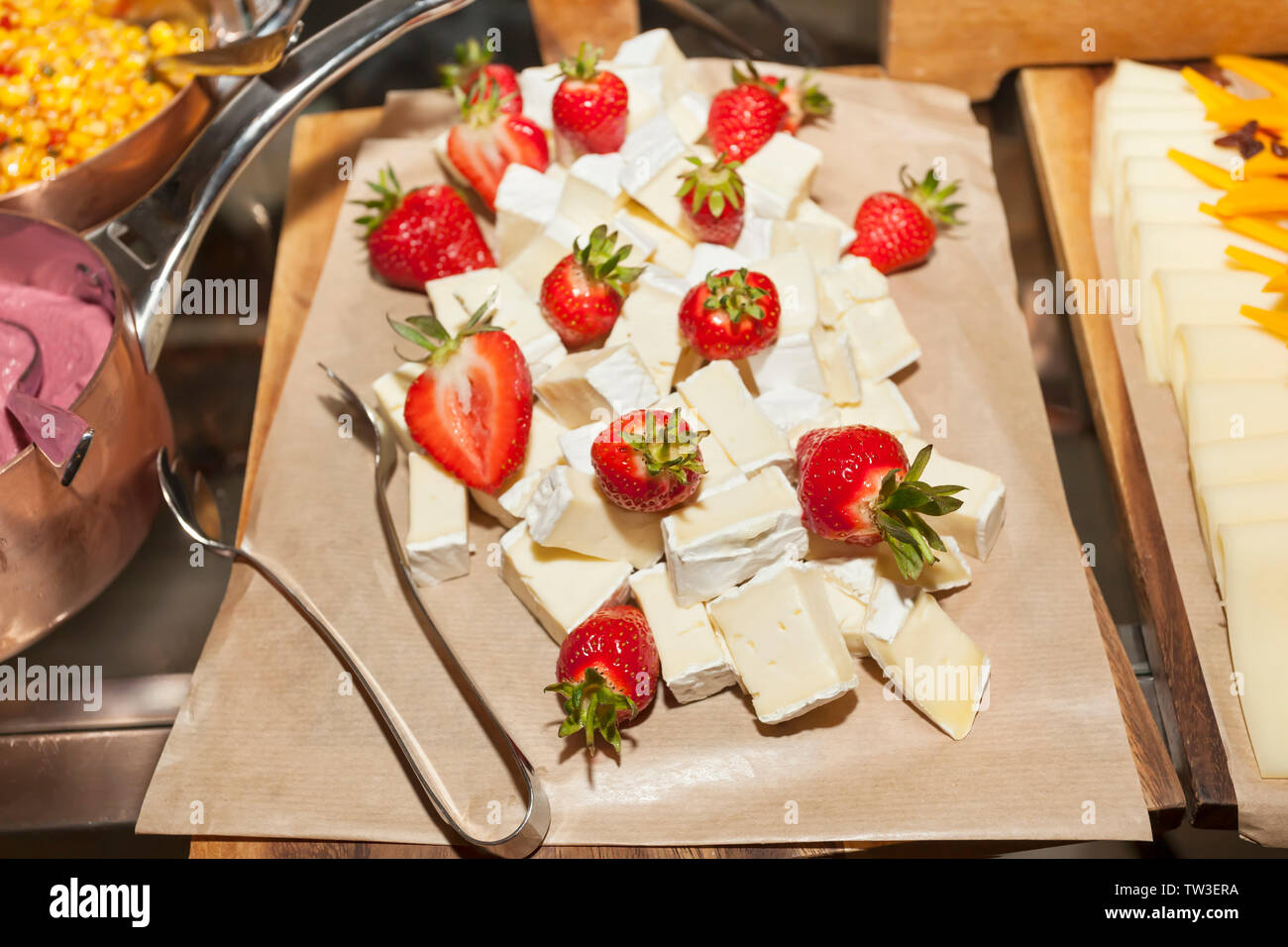 Lecker und gesund Salat mit Erdbeeren und frischer Brie Käse - gesunder Snack auf einem backpapier Stockfoto