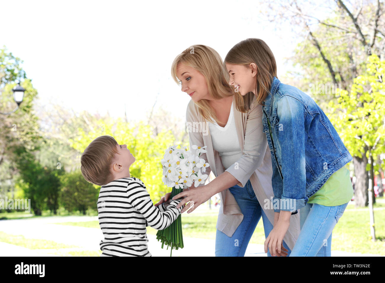 Cute little boy, Blumenstrauß zu seiner Großmutter in Spring Park an einem sonnigen Tag Stockfoto