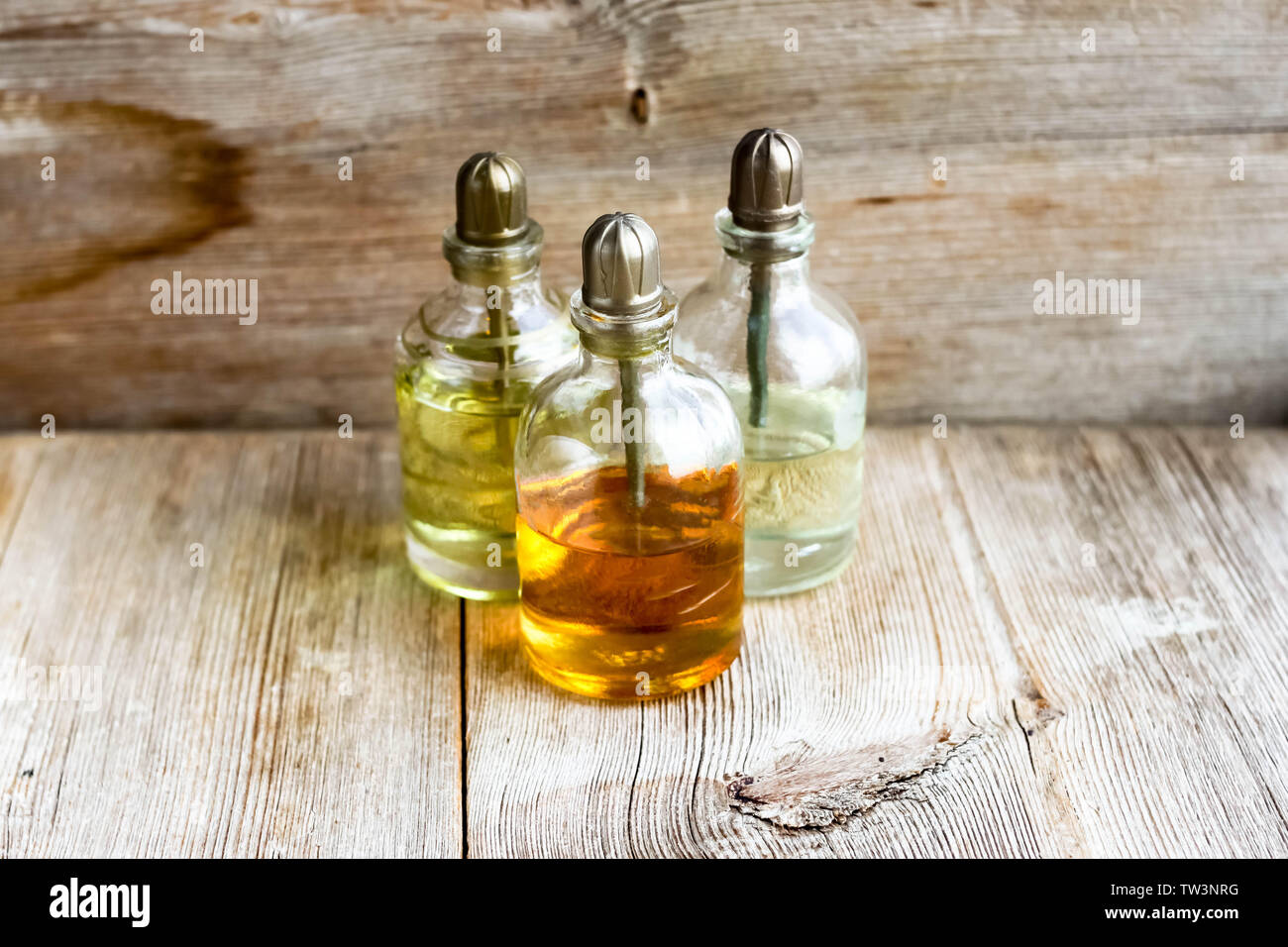 Parfum essence Aroma öl Glas Flaschen in der Nähe von alten hölzernen Hintergrund. Aromatherapie, Spa, Wellness, Entspannung, Massage und Kräutermedizin Konzept. Co Stockfoto