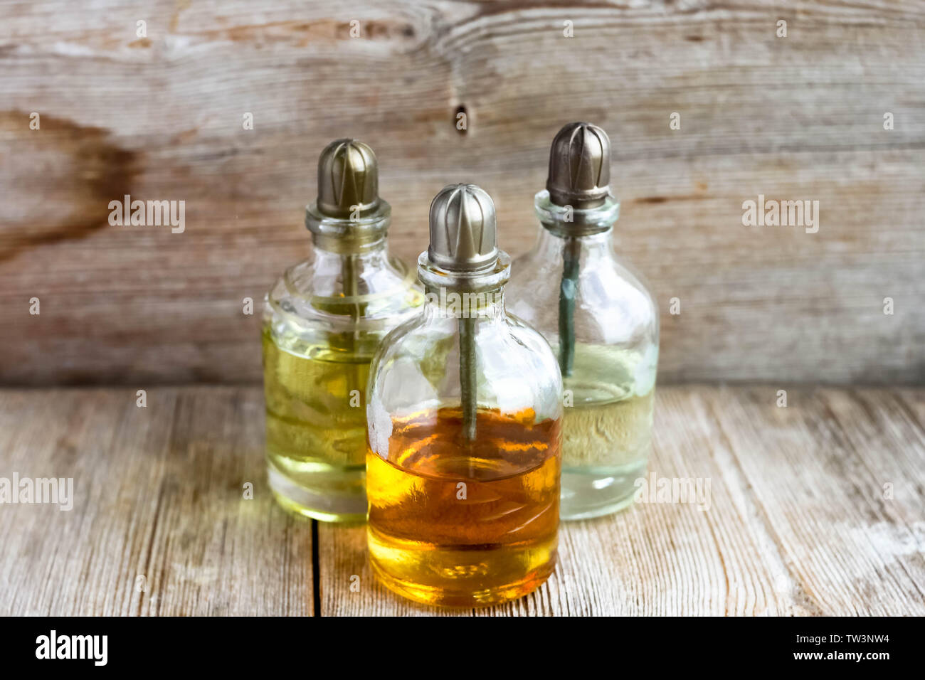 Parfum essence Aroma öl Glas Flaschen in der Nähe von alten hölzernen Hintergrund. Aromatherapie, Spa, Wellness, Entspannung, Massage und Kräutermedizin Konzept. Co Stockfoto