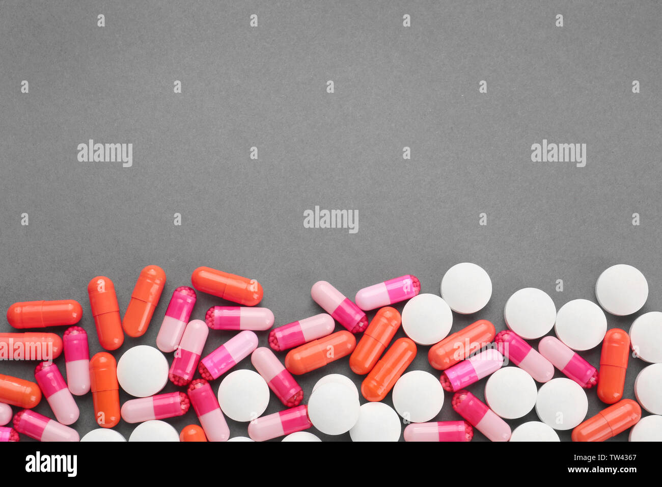 Health Care Konzept. Bunte Pillen auf grauem Hintergrund Stockfoto