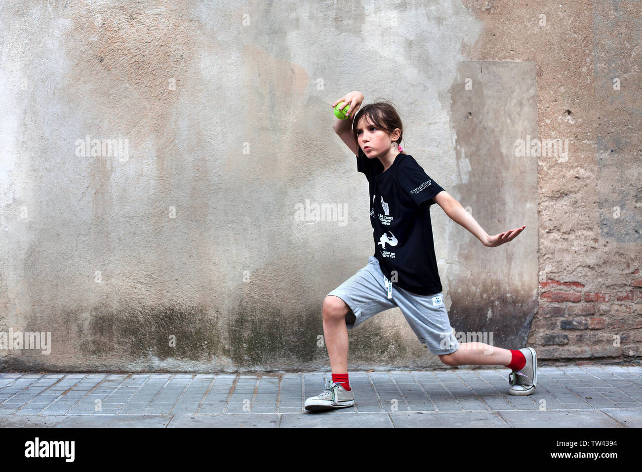 Junge in der Straße spielen mit einem Tennisball. Stockfoto