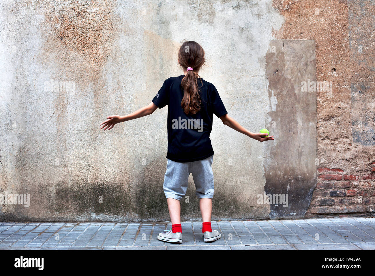 Junge in der Straße vor einer Wand. Stockfoto