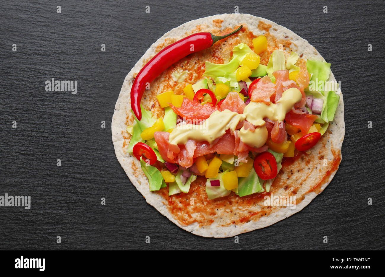 Fisch taco mit Lachs und Chili auf dunklem Hintergrund Stockfoto