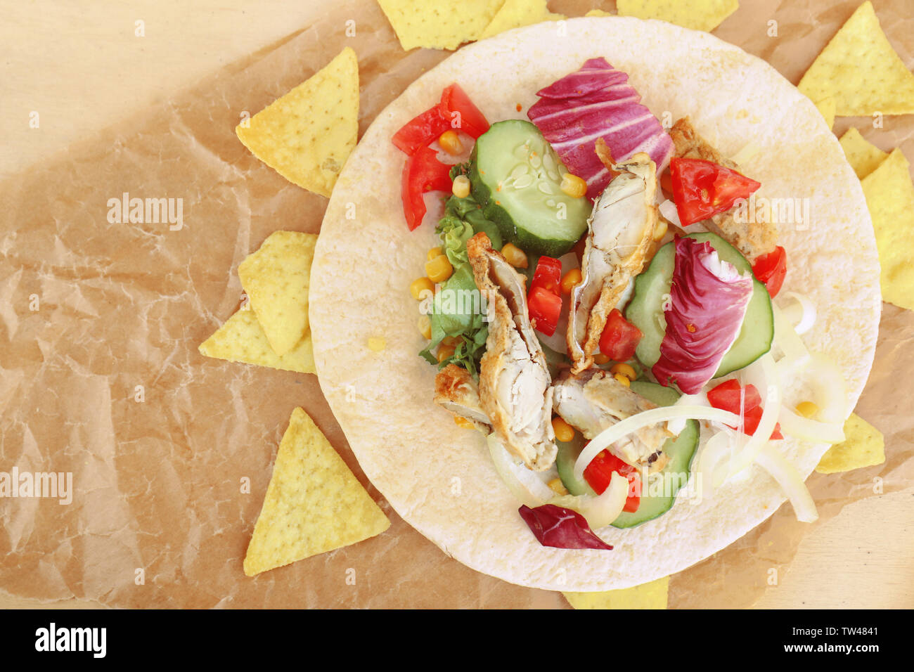 Lecker Fisch taco mit Chips auf Pergament Stockfoto