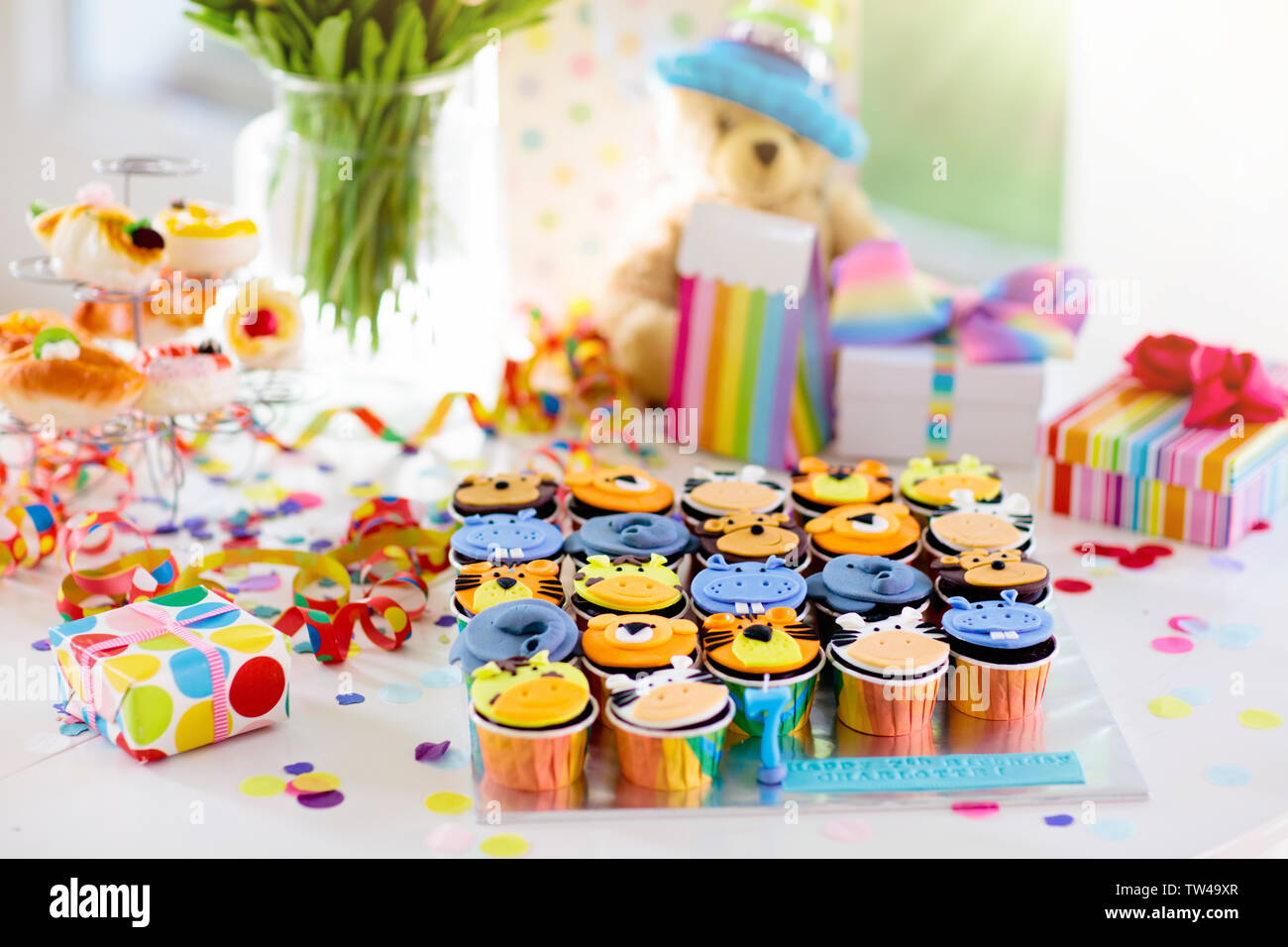 Cupcakes für Kinder Geburtstag feiern. Dschungel Tiere Thema Kinder Party. Zimmer für Junge oder Mädchen Junge Geburtstag eingerichtet. Tabelle Einstellung mit Geschenken, Stockfoto