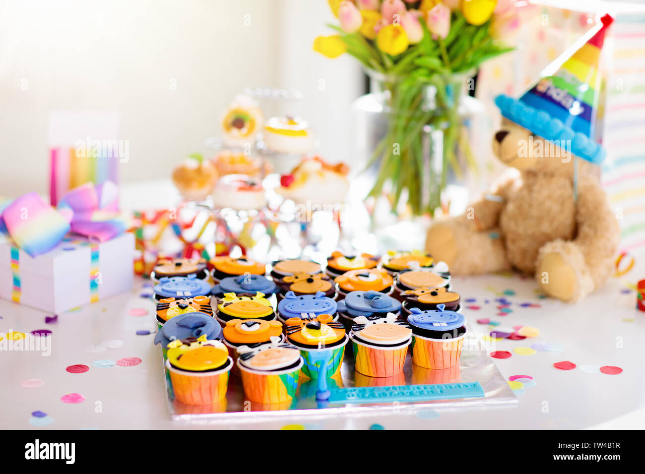 Cupcakes für Kinder Geburtstag feiern. Dschungel Tiere Thema Kinder Party. Zimmer für Junge oder Mädchen Junge Geburtstag eingerichtet. Tabelle Einstellung mit Geschenken, Stockfoto