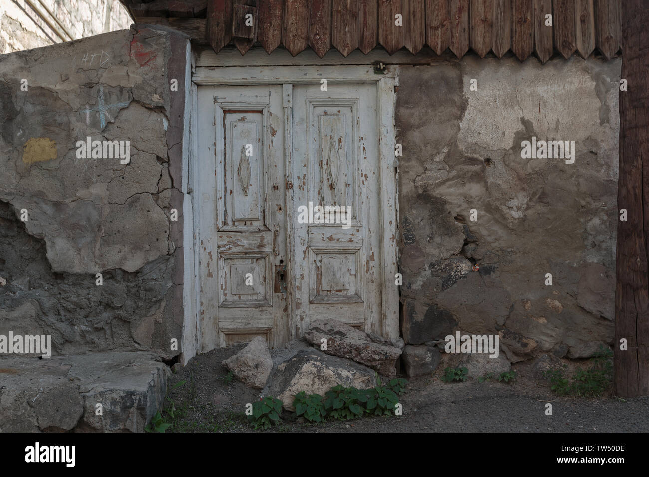 Alte bröckelnden Tür in einem Haus aus Stein Stockfoto