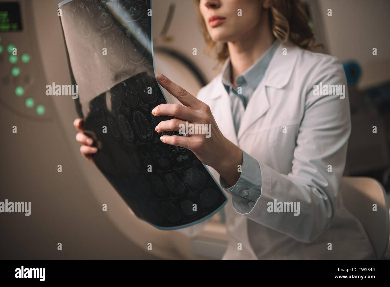 7/8-Ansicht von Radiologen holding Röntgendiagnostik während der Sitzung auf Computertomograph Stockfoto