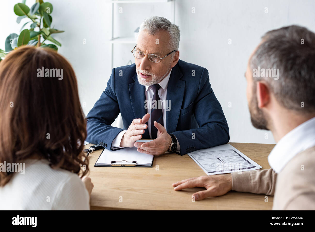 Selektiver Fokus der Autohändler in Gläsern mit Blick auf Kunden, während Sie ein Büro Stockfoto