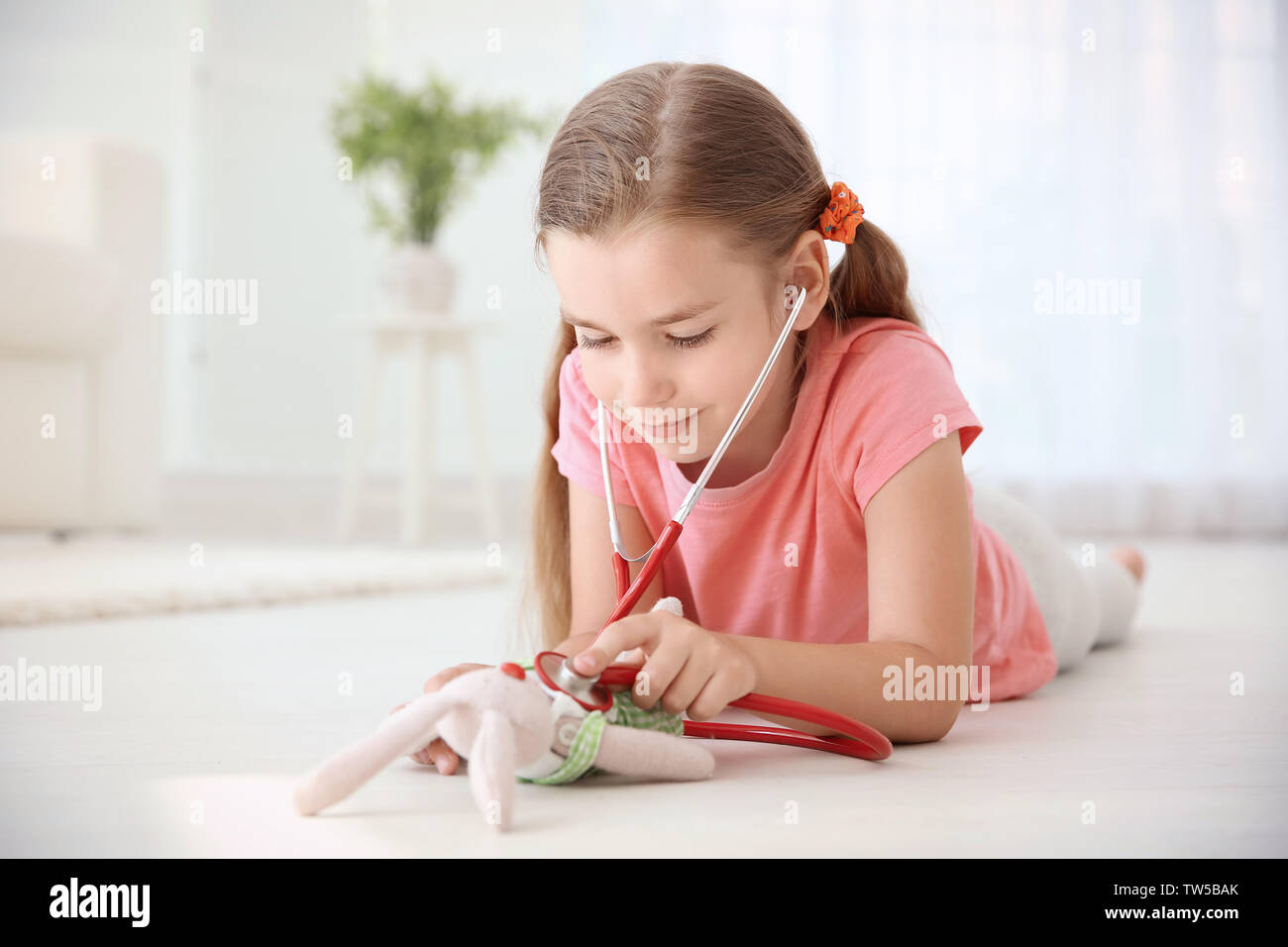 Adorable kleine Mädchen Spielzeug Prüfung mit Stethoskop zu Hause Stockfoto