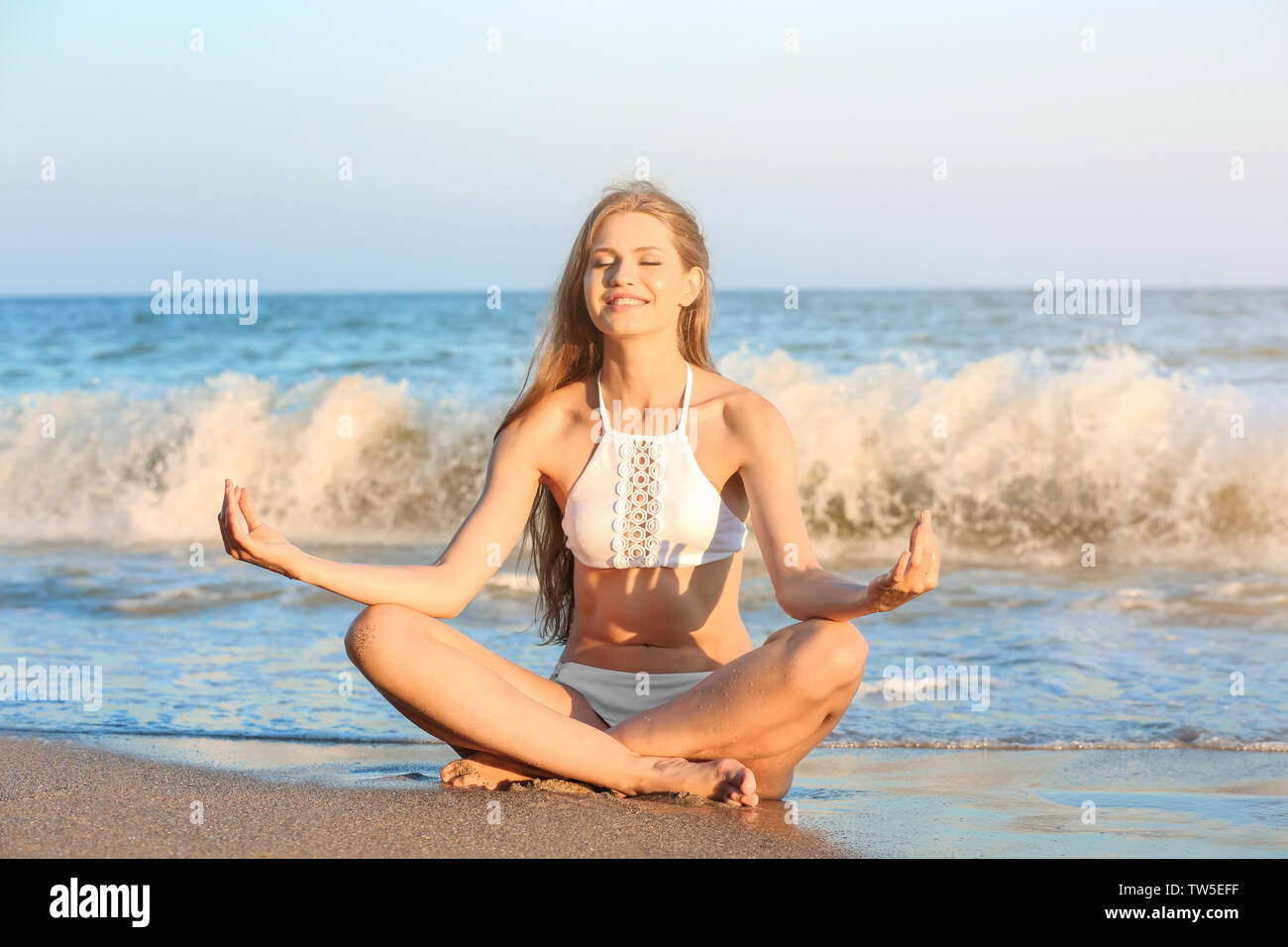 Junge Frau Yoga am Meer Strand Stockfoto